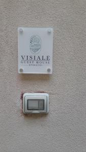 un cartello per una pensione con vista su un muro di Visiale guest house a Spoleto
