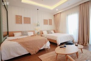 ein Hotelzimmer mit 2 Betten und einem Tisch in der Unterkunft Quy Nhon Beach Apartment - Flc Sea Tower in Quy Nhon