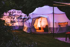 a tent in a field at night at Glamping Camp mit Komfortzelten in Losheim am See in Losheim