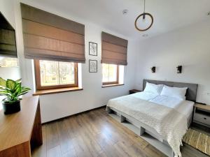 1 dormitorio con 1 cama blanca y 2 ventanas en La Șura, en Şura Mică