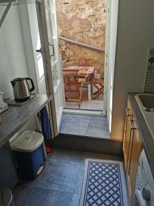 eine Küche mit einer Tür, die auf eine Terrasse mit einem Tisch führt in der Unterkunft Un petit nid douillet ensolleillé à Bouxwiller centre in Bouxwiller