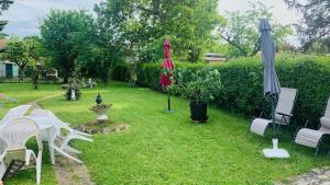 une cour avec des chaises, des parasols et une fontaine dans l'établissement La petite maison de Paule, à Amilly