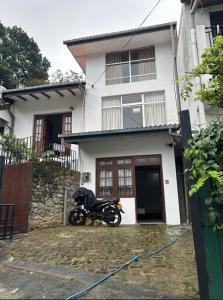 a motorcycle parked in front of a house at Kandy Holiday Home in Kandy