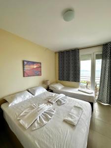 a bedroom with two beds and a window at Rooms Elena in Nea Potidaea