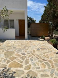 un patio de piedra frente a una casa en AT Espalmador Formentera rustick, en Es Pujols