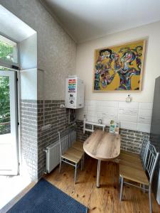ヴィーンヌィツャにあるSWEET hostelのテーブルと椅子、絵画が備わる部屋