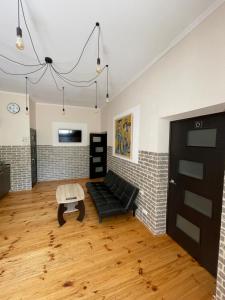a living room with a black couch and a table at SWEET hostel in Vinnytsya