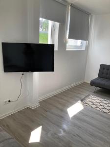 sala de estar con TV de pantalla plana en la pared en Quins, en Aalen