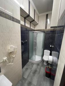 a bathroom with a glass shower and a toilet at SWEET hostel in Vinnytsya