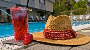 un cappello di paglia e un vaso con una fragola sul tavolo di Sportcamping & Glamping Resort Rio Vantone a Crone