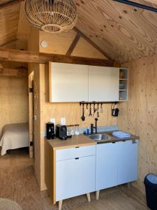 a kitchen with white cabinets and a sink at Eb en Vloed in Huisduinen