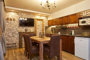 a kitchen with a table and chairs and a fireplace at Magic apartment in Mezőkövesd