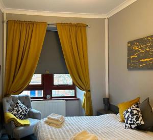 a bedroom with a bed and a window with yellow curtains at Mustard Seed 43 Seamore Street 1/L Largs in Largs