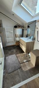a bathroom with a sink and a desk and a mirror at Le 6 bis avec Jardinet in Guéméné-Penfao +14 photos