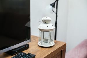 a white lantern sitting on a table next to a computer monitor at Weeksa Vacation Home in Duga Resa