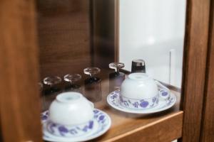 two tea cups and saucers on a wooden shelf at Weeksa Vacation Home in Duga Resa