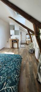sypialnia na poddaszu z łóżkiem i drewnianą podłogą w obiekcie Le 6 bis avec Jardinet w mieście Guéméné-Penfao