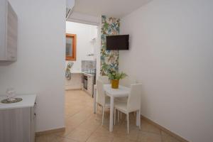 cocina y comedor con mesa blanca y sillas en Quattrociocchi apartment, en Bagheria