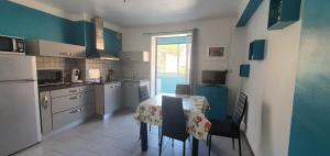 - une cuisine avec une table et des chaises dans la chambre dans l'établissement Appartement calme à quelques pas du port, à Port-Vendres