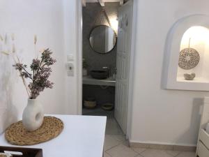 a white vase sitting on a table in a bathroom at Francesca Secret in Mikonos +19 photos