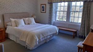 a bedroom with a large bed and a window at Elibank House B&B in Walkerburn
