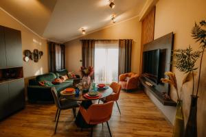Villa Sunset Pool & Spa apartments في زْغورنيي سْكوفييي: غرفة معيشة مع طاولة وأريكة