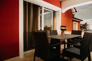 una mesa con sillas y una copa de vino. en Villa Sunset Pool & Spa apartments, en Zgornje Škofije