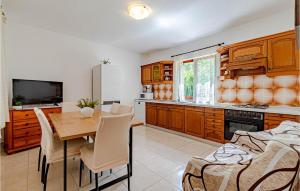 ルンバルダにあるHoliday Home Przina Ivのテーブルと椅子のあるキッチンとダイニングルーム