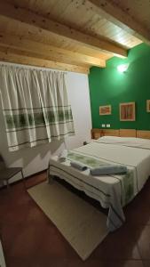 1 dormitorio con cama y pared verde en B&B Kikina, en Austis