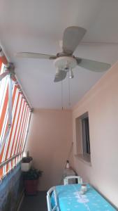 a ceiling fan in a room with a window at Chez Bianca Les Coquelicots Les Lucioles in Menton