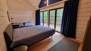1 dormitorio con cama y ventana grande en Peipsi Villad, en Kuru