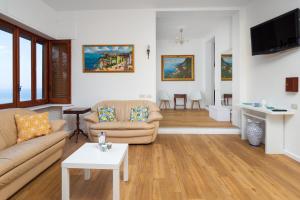 salon z kanapą i stołem w obiekcie Villa Cristina - De Vivo Realty Piano di Sorrento w mieście Piano di Sorrento