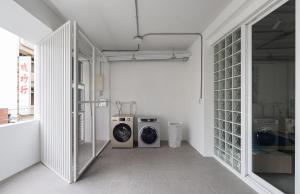 a laundry room with a washing machine and a washer and dryer at Timios Inn 提米好旅 in Changhua City