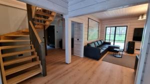 ein Wohnzimmer mit einer Treppe und einer Couch in der Unterkunft Peipsi Villad in Kuru