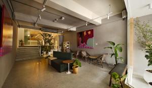 彰化市Timios Inn 提米好旅的客厅里有一张沙发、一张桌子和几把椅子。