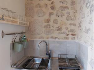 cocina con fregadero y pared de piedra en Ravissant studio à la ferme avec piscine, en Jau-Dignac-et-Loirac