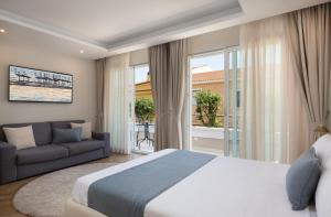 a bedroom with a large bed and a couch at Télos Rooms in Villasimius