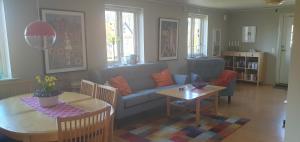 salon z kanapą i stołem w obiekcie Gårdshuset i Simrishamn w mieście Simrishamn