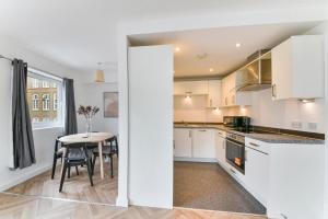 a kitchen with a table and a dining room at Amazing 2 Bedroom Flat In Canary Wharf in London