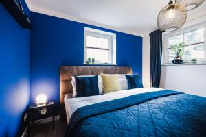 a blue bedroom with a bed with blue walls at Ferienwohnung "UtTied" - komfortabel und modern! in Klausdorf Mecklenburg Vorpommern