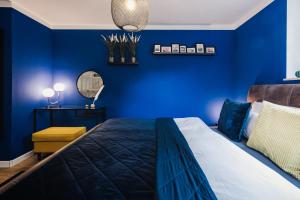 a blue bedroom with a bed and a mirror at Ferienwohnung "UtTied" - komfortabel und modern! in Klausdorf Mecklenburg Vorpommern