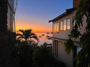 una casa con vistas al océano al atardecer en Blue Parrot, en Labuan Bajo