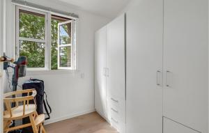 Habitación blanca con silla y ventana en Awesome Home In Malling With Wifi And 3 Bedrooms, en Malling
