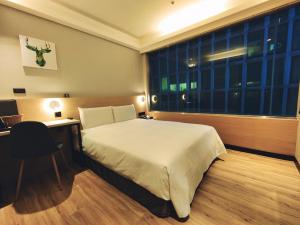 台北的住宿－旅居文旅 松山驛站，一间卧室配有一张床、一张书桌和一个窗户。