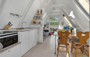 kuchnia z białymi szafkami oraz stołem i krzesłami w obiekcie Gorgeous Home In Allinge With Kitchen w mieście Allinge