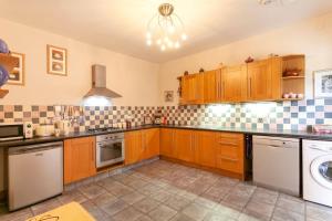 a kitchen with wooden cabinets and a dishwasher at Garden cottage in South Collingham