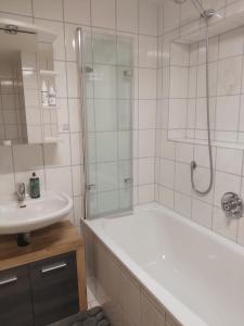 a bathroom with a white tub and a sink at Ferienwohnung Reinhold in Schönbrunn am Lusen in Hohenau