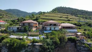 a group of houses on a hill with mountains at Guest House Bracaj in Çorovodë