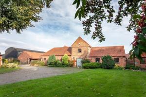 an estate with brick buildings and green grass at Garden cottage in South Collingham