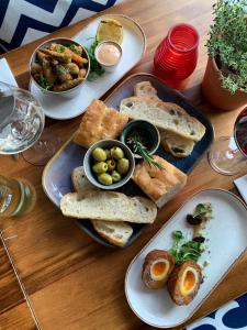 a table topped with plates of bread and bowls of food at The Lugger Inn in Polruan